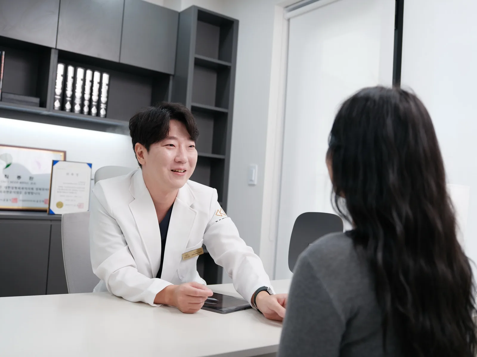 Dr. Jonghwan Choi talking through aftercare with a patient at Rewind Plastic Surgery