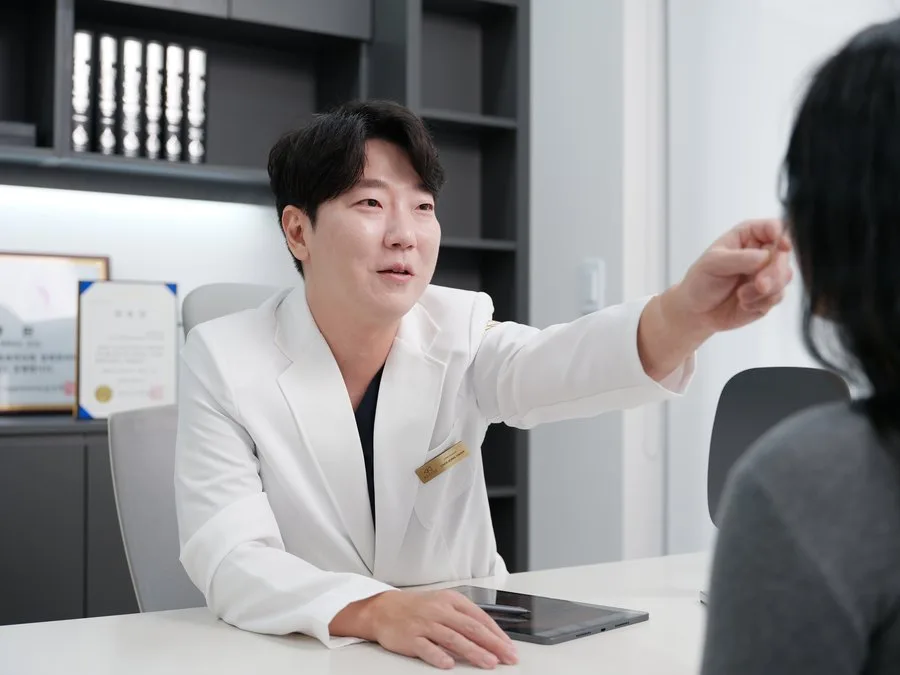 El Dr. Jonghwan Choi explica la línea mandibular a una paciente en consulta